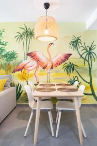 La MaretaApartamentos Las Terrazas de Sotavento的一间用餐室,配有粉红色火烈鸟壁画