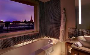 布拉格The Grand Mark Prague - The Leading Hotels of the World的带浴缸、水槽和窗户的浴室
