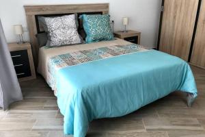 阿利坎特Espacioso y céntrico piso con zona chill-out的一间卧室配有一张大床,提供蓝色的床单和枕头