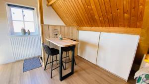 阿赫特克克Studio Burg.bosselaarstraat的一间小厨房,内设桌子和冰箱