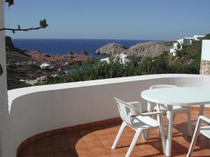 卡拉莫若尔萨考尼公寓式酒店的一个带桌椅的海景阳台