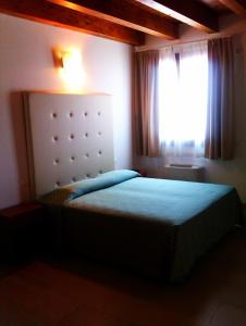 坎帕那鲁皮亚拉奇欧齐亚农庄酒店的一间小卧室,配有一张带窗户的床