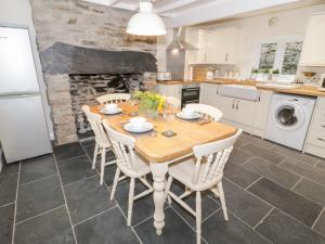 布莱奈费斯蒂尼奥格Garreg Lwyd的厨房配有木桌和白色家电