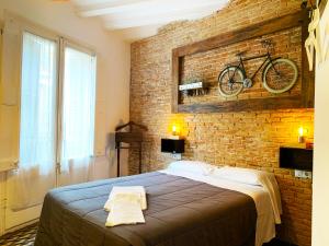 巴塞罗那Hostal Portugal的卧室配有一张床,墙上挂着自行车