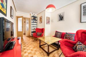 奥维多Magnifico apartamento en el centro de Oviedo的客厅配有红色家具和桌子