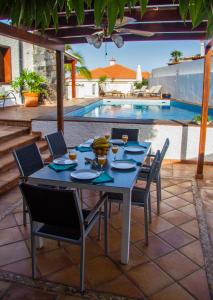 圣地亚哥港Villa Punta Negra HEATED POOL tenerifesummervillas的一个带游泳池的庭院里摆放着桌椅