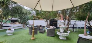 马德里Escala Suites的庭院设有椅子和遮阳伞,树木繁茂。