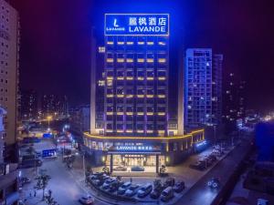 赣州麗枫酒店(赣州火车站店)的一座建筑物,上面有夜间标志