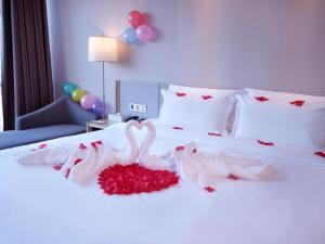 哈尔滨Lavande Hotel (Harbin Ice and Snow World University of Commerce Branch)的一张带两个天鹅的红色玫瑰床