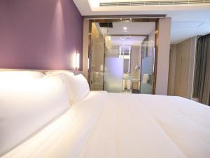 咸阳Lavande Hotel Xianyang Yuquan Road Wanda Plaza Branch的带淋浴的客房内一张大白色床