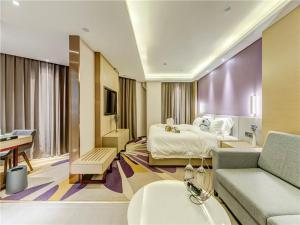 唐山Lavande Hotel Tangshan Convention and Exhibition Yuanyang City的酒店客房,配有床和沙发