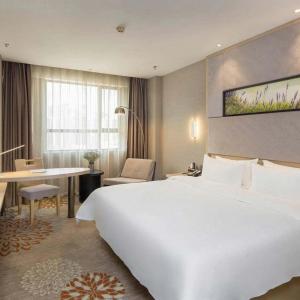 长沙Lavande Hotel Changsha High-speed Railway Station Shuling的酒店客房设有一张白色大床和一张书桌