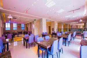 信阳Lavande Hotel Xinyang Municipal Government Branch的一间配备有桌子和蓝色椅子的用餐室