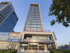 临汾Lavande Hotel (Linfen Binhe East Road Yujing Shuicheng Branch)的一座高大的建筑,上面有标志