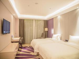 沧州Lavande Hotel Cangzhou Kaiyuan Avenue Rongsheng Plaza的酒店客房配有两张床和一张书桌