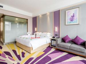 星沙Lavande Hotel Changsha Xingsha Center的一间卧室配有一张大床和一张沙发