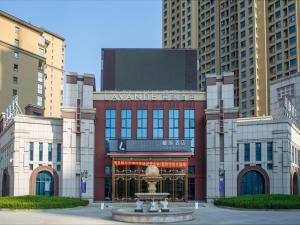 沧州Lavande Hotel Cangzhou Kaiyuan Avenue Rongsheng Plaza的一座大型建筑,前面有一个喷泉