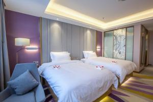 抚州Lavande Hotel (Fuzhou Wanda Branch)的酒店客房,配有两张床和椅子