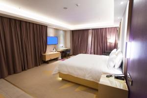 日照Lavande Hotel Rizhao Xinshi District Branch的配有一张床和一张书桌的酒店客房