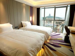 九江Lavande Hotel Jiujiang Jiujiang College的酒店客房设有两张床和大窗户。