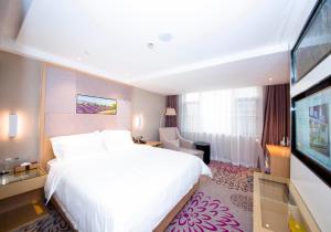 常德Lavande Hotel Changde Pedestrian Street Branch的酒店客房设有一张大床和一台电视机。