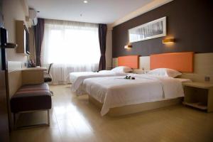 焦作7 Days Premium Jiaozuo Renmin Road Teachers College的酒店客房设有两张床和窗户。