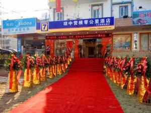琼中7Days Inn Qiongzhong Zero Kilometer的长长的红地毯上的人穿着橙色服装