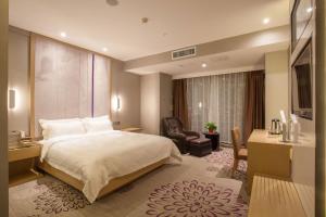徐州Lavande Hotel Xuzhou West Exit of High Speed Rail Station Branch的酒店客房配有一张床、一张桌子和一把椅子。