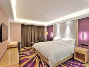 四平Lavande Hotel (Siping Wanda Plaza Branch)的酒店客房设有一张大床和一张沙发。