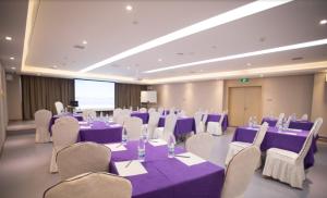 长春Lavande Hotel (Changchun Yiqi Branch)的一间设有紫色桌子和白色椅子的房间,一间设有紫色桌子和白色的房间