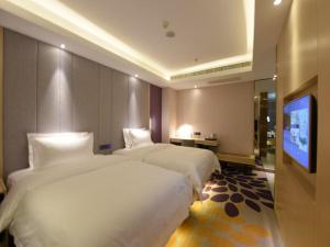 长春Lavande Hotel Changchun Hangkong University Fanrong Road Metro Station的酒店客房设有两张床和一台平面电视。