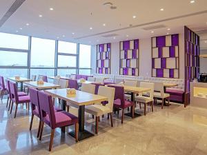 邯郸Lavande Hotel Handan Congtai Park New Century Plaza的餐厅设有桌子、紫色椅子和窗户