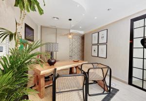 贝尼多姆Don Cesar Boutique Apartments的一间带木桌和椅子的用餐室
