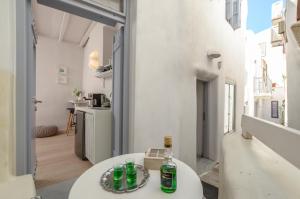 纳克索乔拉Venetian Suites的一间设有白色桌子的房间,上面装有瓶子