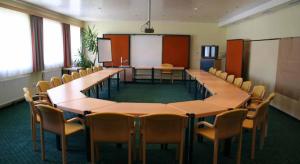 伊布斯河畔格施特灵Hotel Waldesruh的一间会议室,在教室里配有桌椅