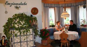 伊布斯河畔格施特灵Hotel Waldesruh的坐在餐厅桌子上的男女
