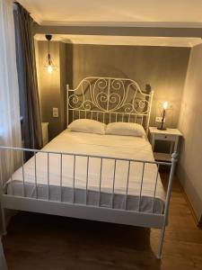 恰纳卡莱克兹公寓的卧室配有白色床和锻铁床头板