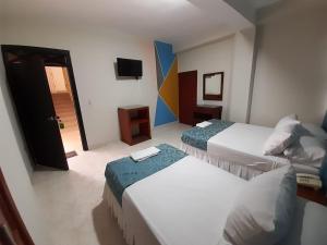 库库塔Hotel El Andino的酒店客房设有两张床和电视。