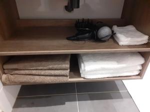 Saint-Georges-de-LuzençonStudio Le Ménascle的浴室内带毛巾和毛巾的木制架子