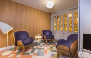 巴黎白兔子酒店的一间配备了紫色椅子和笔记本电脑的等候室
