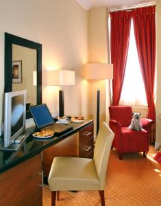 爱丁堡国会大楼酒店的客房设有书桌、电脑和红色椅子