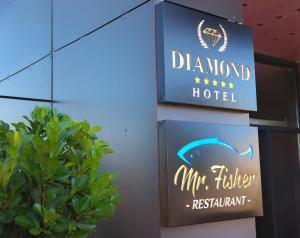 普里什蒂纳Hotel Diamond Prishtina的植物旁酒店标志