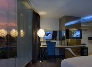 曼谷The Xtreme Suites的一间卧室配有书桌和电视。