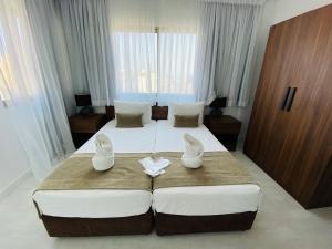 拉纳卡爱诺拉公寓酒店的酒店客房,配有两张床,并带鞋