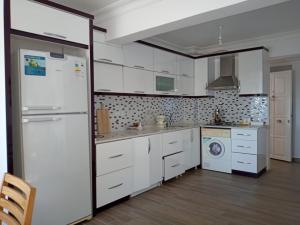 卡斯Heybe Apart的厨房配有白色橱柜和白色冰箱。