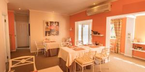 Riebeek-WesChurch Hills Boutique Accommodation的一间设有两张桌子和椅子的客房,以及橙色的墙壁