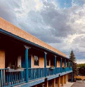 圣达菲瓜达卢佩旅馆的拥有蓝色柱子和阳台的建筑