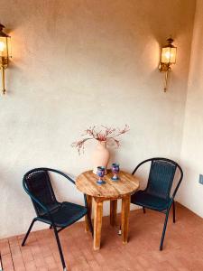圣达菲瓜达卢佩旅馆的两把椅子和一张木桌,上面有花瓶