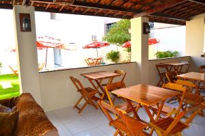 福塔莱萨波隆戈迪旅馆的餐厅设有木桌、椅子和遮阳伞