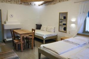 达默查理Ghermaniko Guesthouse的客房设有两张床、一张桌子和一张书桌。